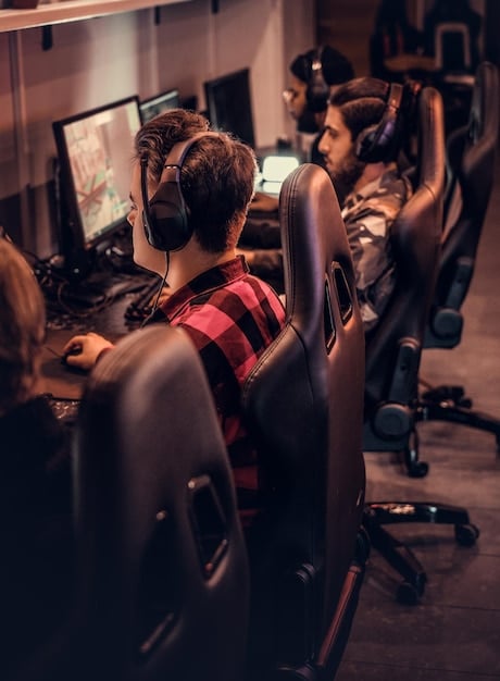A high-tech eSports gaming house with multiple professional gamers training at their computer setups, surrounded by team branding and modern decor.