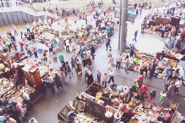 A bustling convention floor filled with cosplayers, vendors selling pop culture merchandise, and large promotional displays, emphasizing the vibrant economic activity driven by fan events.