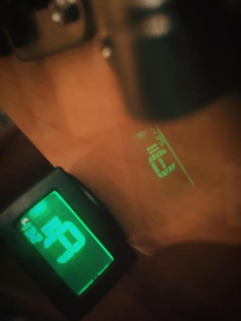A close-up of an athlete's arm with biosensors attached, showing a sleek monitor displaying intricate real-time physiological data patterns, symbolizing advanced biofeedback.