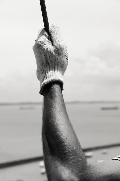 A detailed close-up of a golfer's hands on the grip of a golf club, with a screen in the blurred background showing swing metrics and data.