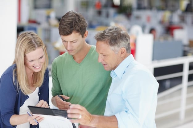 A group of manufacturing executives discussing AR integration in a modern factory setting, with tablets displaying AR concepts.