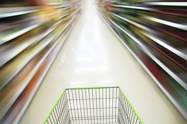 A full shopping cart overflowing with fresh produce, groceries, and packaged foods, set inside a brightly lit supermarket aisle, conveying the idea of consumer food costs.